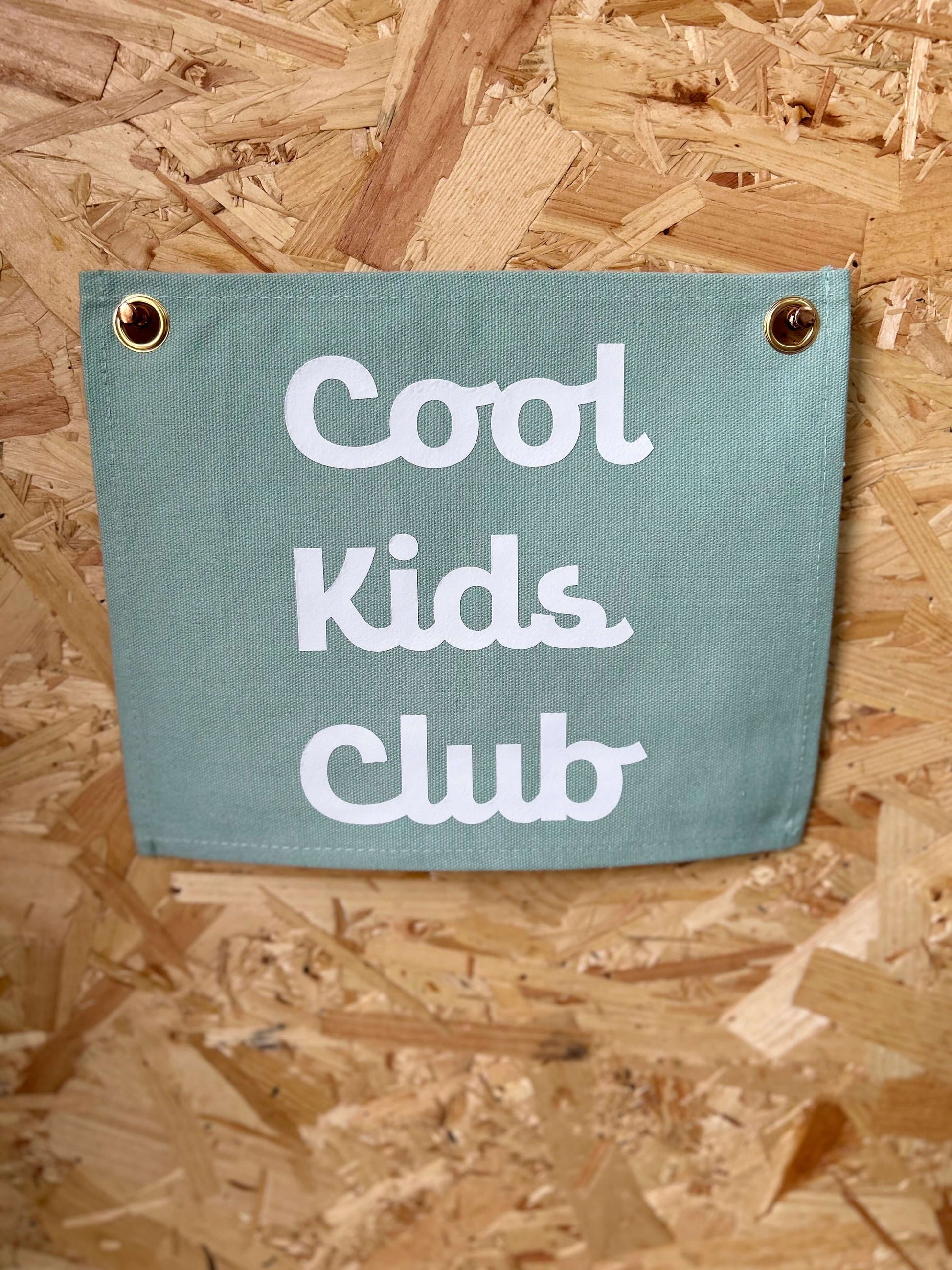 Sage green wall flag with cool kids club on it