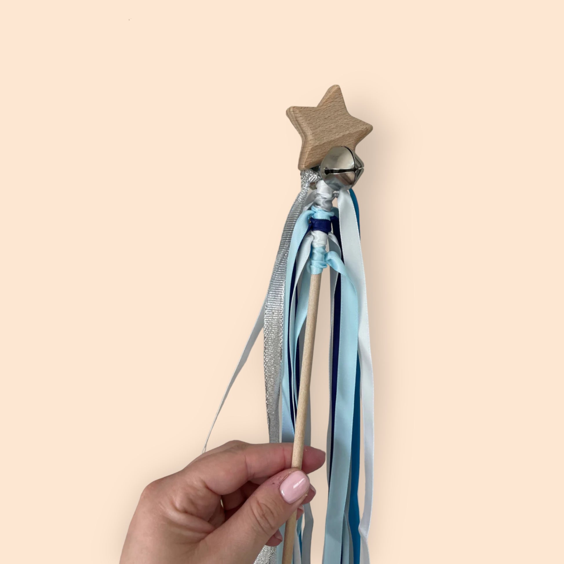 wooden wand with bells and ribbon
